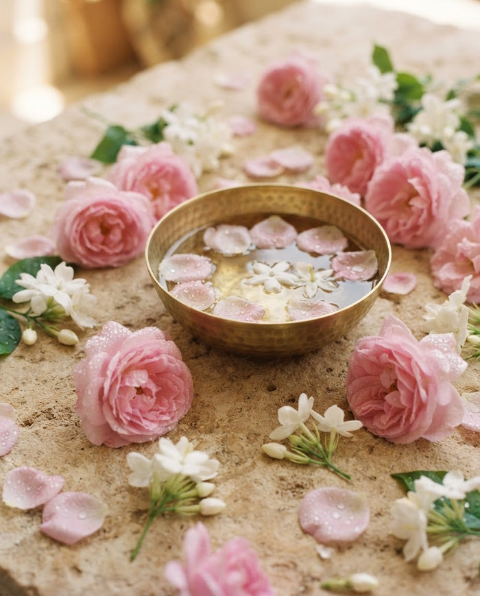 Floral fragrance family — rose and jasmine petals beside a perfume bottle